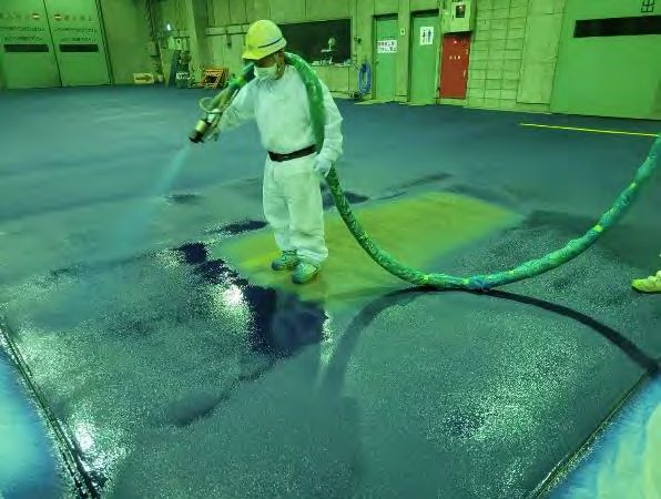 清掃クリーンセンターの床にポリウレアを吹き付けている様子