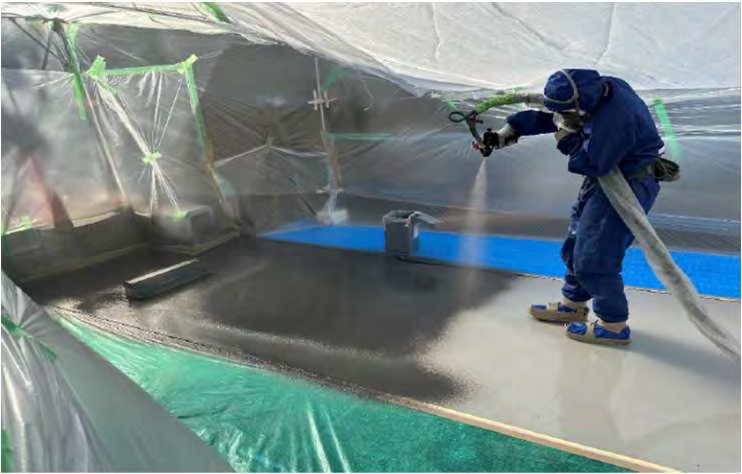 紙工場の場内駐車場にポリウレアを吹き付けている様子
